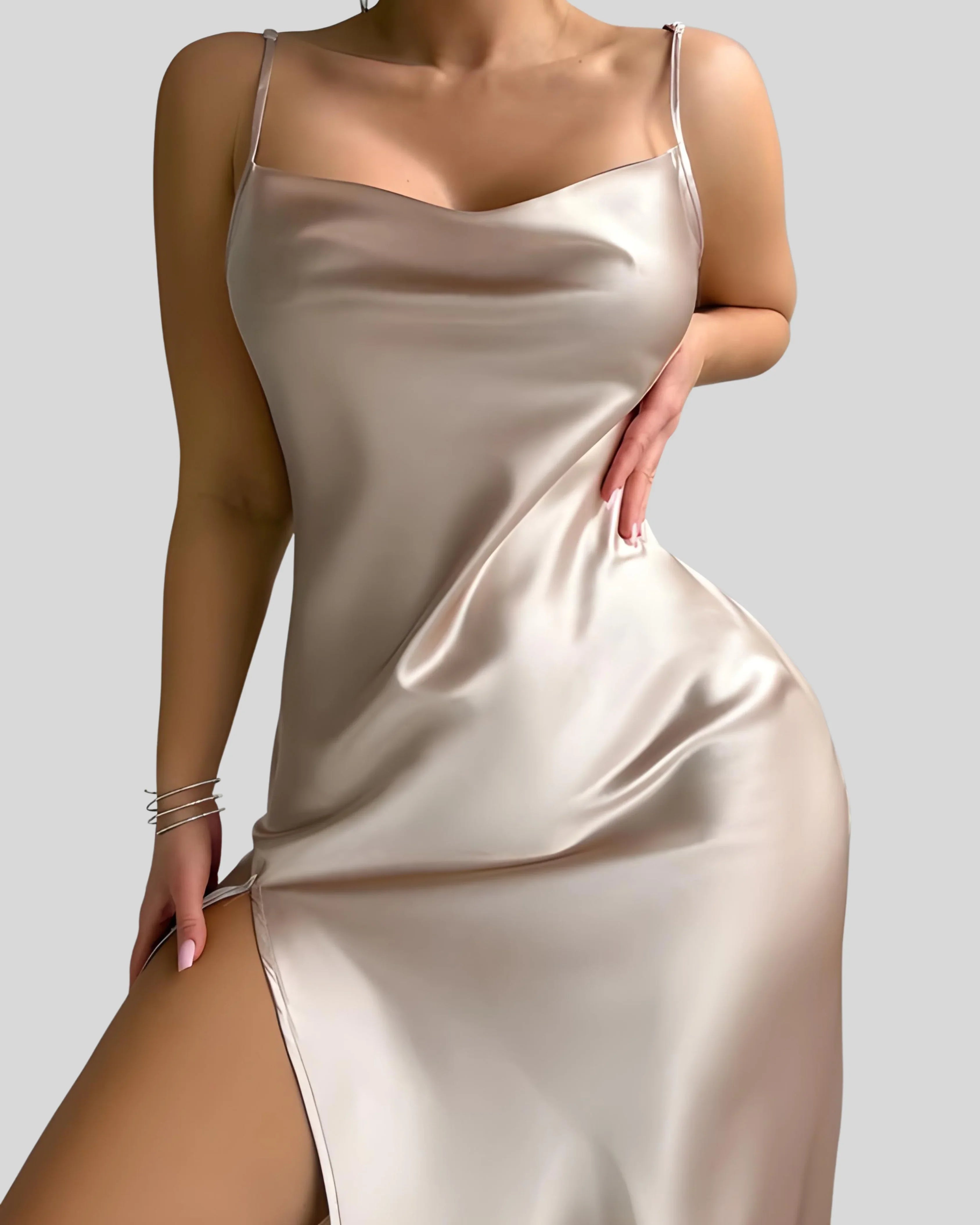 Woman wearing a champagne-colored satin slip dress with spaghetti straps and thigh-high slit, styled with bracelets and hoop earrings